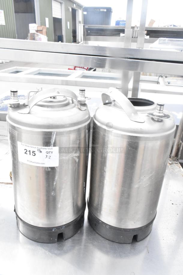 Two metal 3-gallon kegs with stainless steel finish, carrying handles, and visible auction label indicating "215. QTY x2".