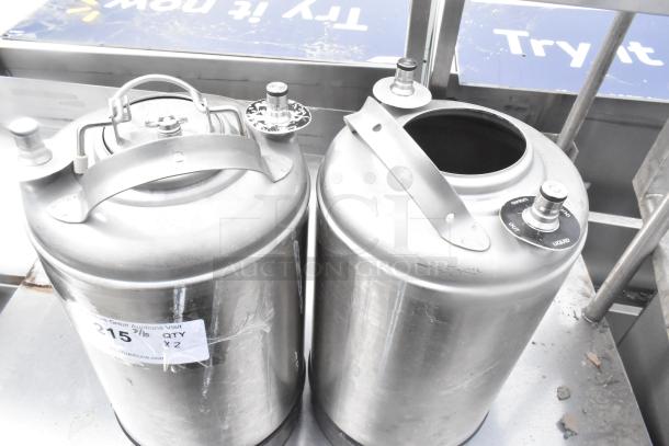 Two metal 3-gallon kegs, lightly used, with secure handles and spouts. Auction label indicates quantity of two.