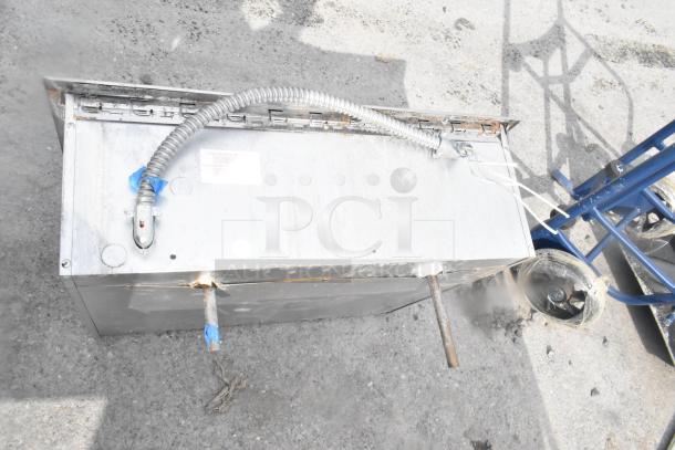 Commercial 2 well drop-in food warmer in used condition, showing metal body and attached power conduit. Labels present.