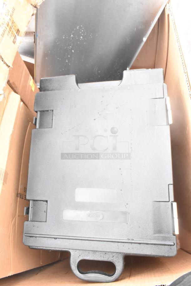 Black Cambro front load catering case, brand new with minor scratches, shown in original packaging.