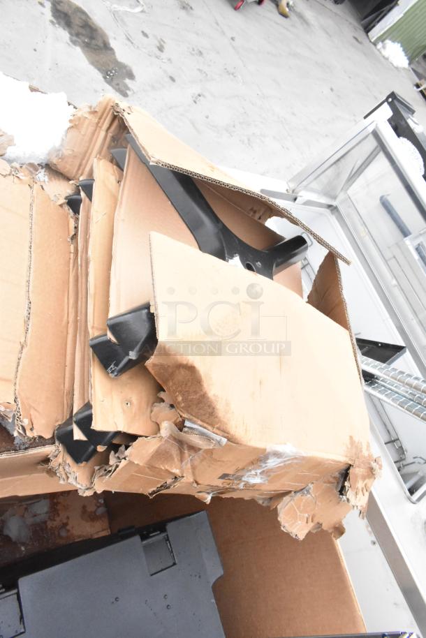 Box containing mixed catering items, including a Cambro front load case and trays, with visible damage on packaging.