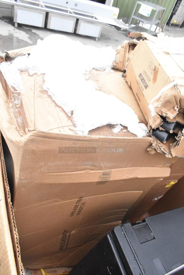 Damaged cardboard box containing Cambro catering case, bun warmer, trays, and ingredient bin. Box shows visible wear and tear.