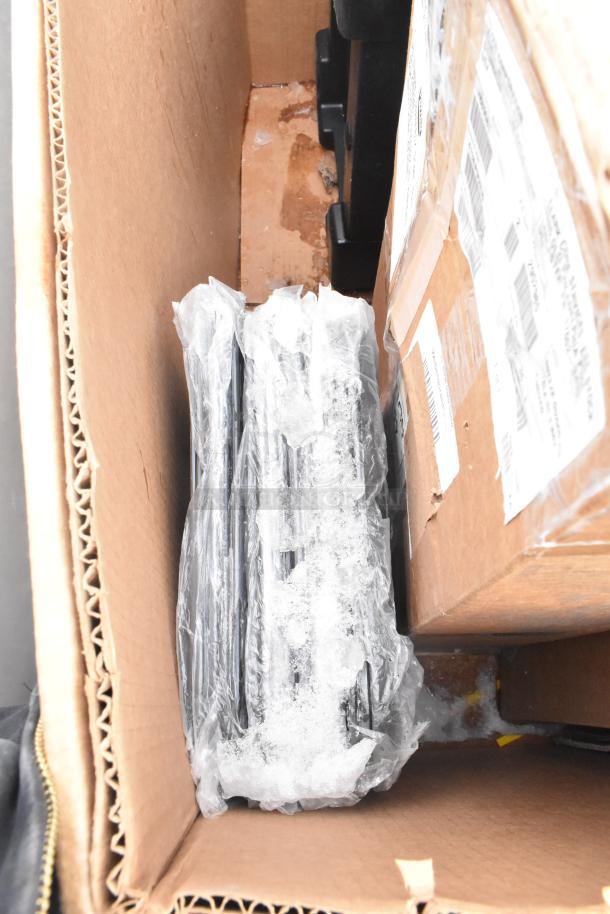 Box containing new scratch and dent items, including a Cambro front load catering case, bun warmer, and trays.