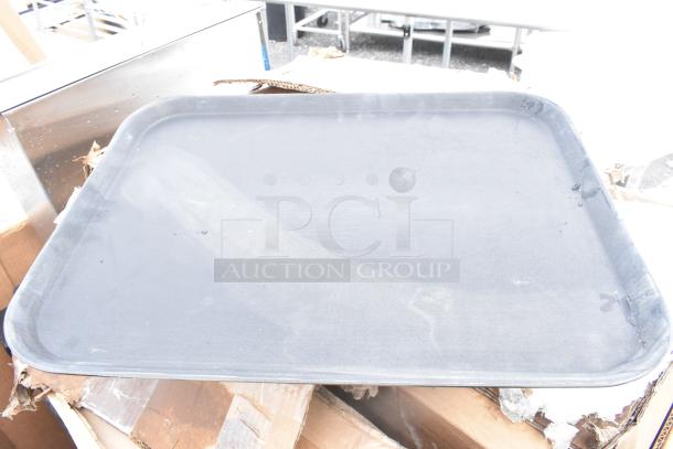 Black catering tray on top of damaged cardboard, part of a set including Cambro case and more. New scratch and dent items.