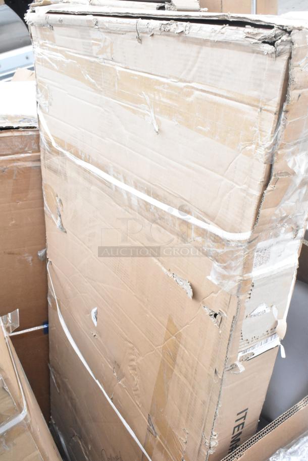 Cardboard box containing new scratch and dent items, including evaporator coil and shelves. Box shows wear, taped edges.