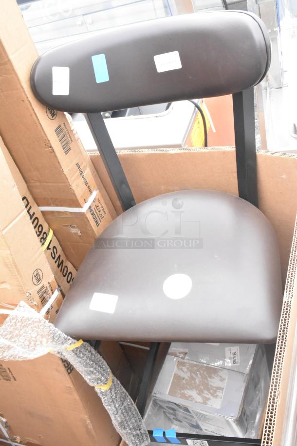 Box containing a new black chair with tags, amidst packaging materials, shelves, and equipment including an evaporator coil.