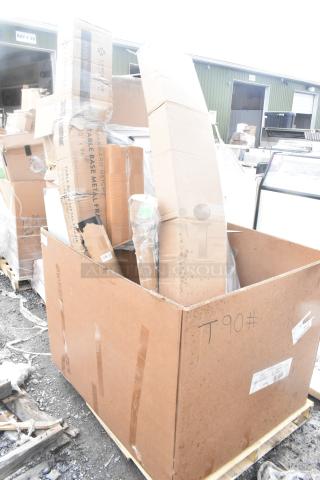 Box of 17 new scratch and dent items, including table and platform truck, in original packaging, on a wooden pallet.