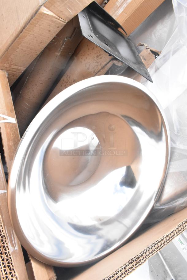 Scratch and dent lot with metal basin, cardboard boxes, black metal part. New condition items for auction.