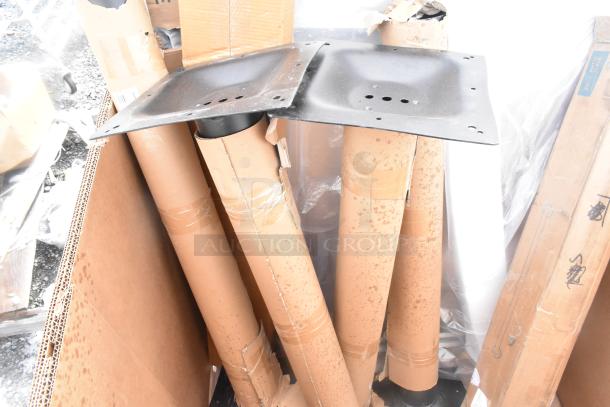 Cardboard box with metal table legs partially wrapped in cardboard. Some boxes appear worn, indicating scratch and dent condition.