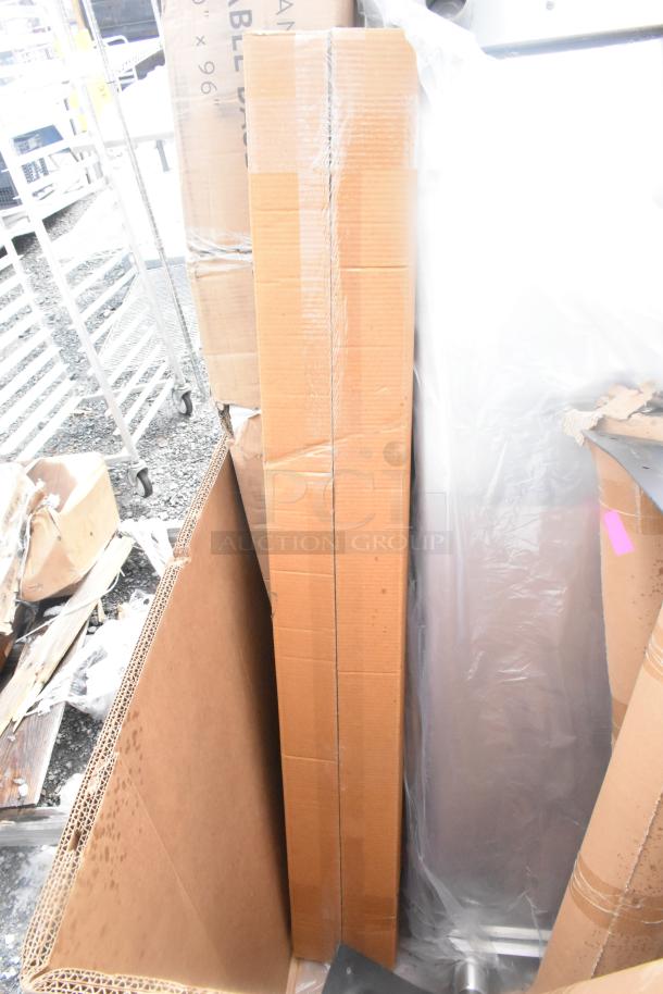 Auction lot with various scratch and dent items, including table and platform truck, packed in cardboard boxes, new condition.