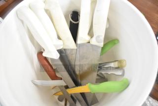 White poly bucket containing assorted kitchen knives with various colored handles; items appear gently used.