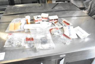 Assorted items including light bulbs and packaged components on a table. Items in mixed condition with various labels.