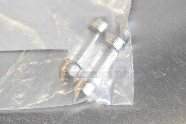 Plastic bag with two cylindrical light bulbs featuring metal caps; part of a mixed auction lot.