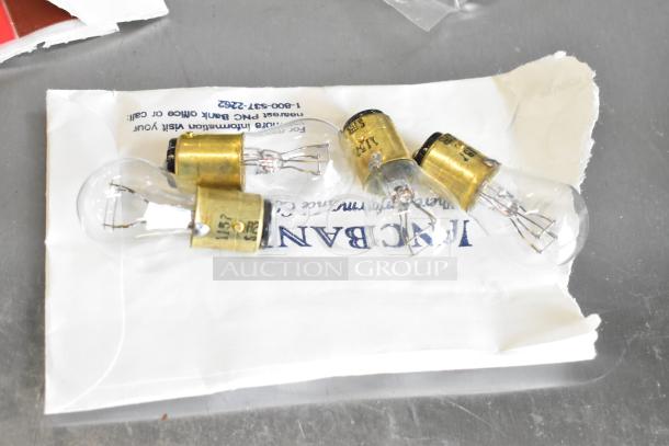 Lot of various small light bulbs on a white envelope, brass bases with visible markings. Ideal for collectors or DIY projects.