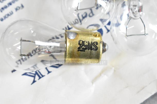 Lot of light bulbs with brass bases, one marked "92MS." Bulbs appear intact with clear glass. Mixed item collection.