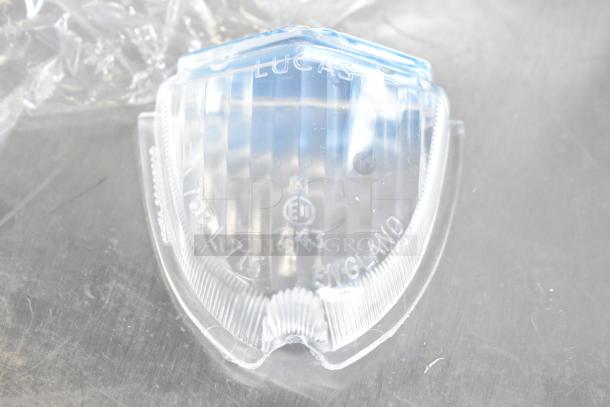 Clear Lucas light bulb cover, marked with "Lucas," "England," and "E11 7143." In good condition, suitable for collectors.