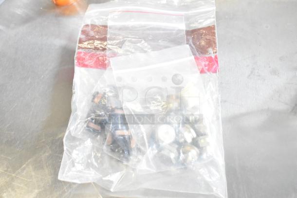 Plastic bag containing a mixed lot of small hardware items and light bulbs, varying in shape and size.