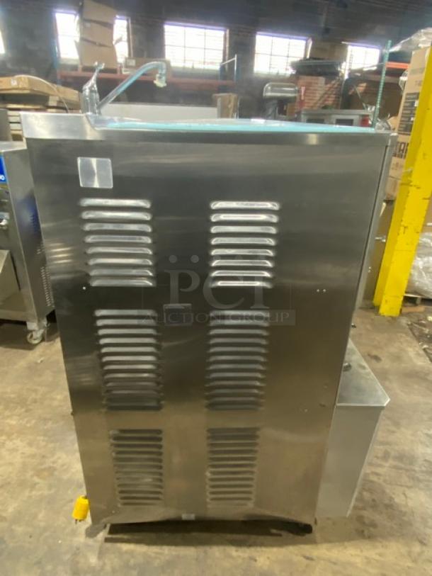 ColdElite UF820-2 commercial stainless steel soft serve machine, 208V 3 phase, on casters, side view in warehouse.