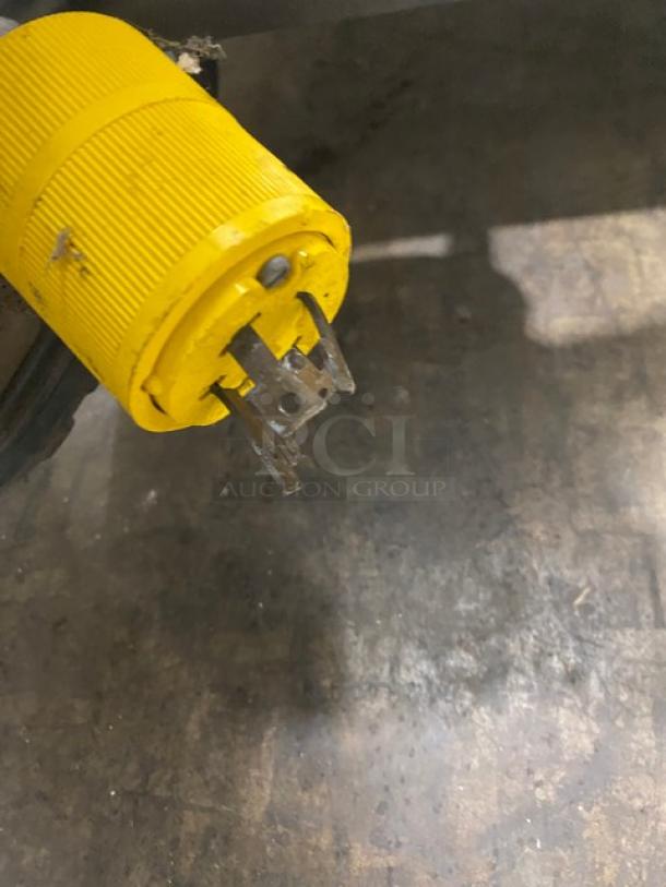 Yellow power plug of ColdElite UF820-2 ice cream machine, 208V, on a floor surface.