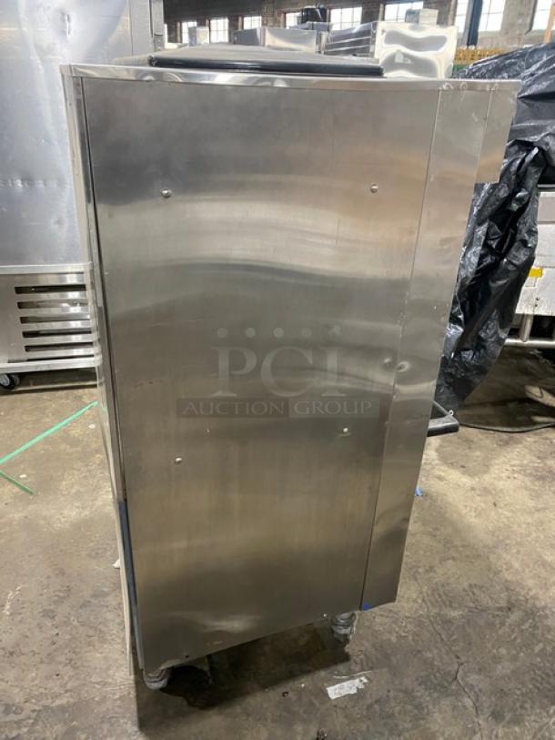 Electro Freeze stainless steel soft serve machine, electric-powered, twin/twist model with 2 hoppers, 3 dispensers, on casters.