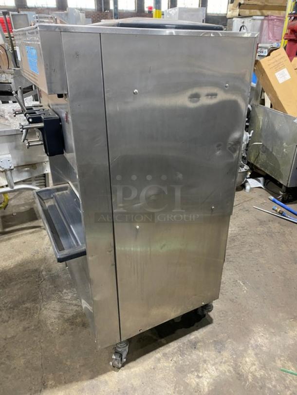 Electro Freeze twin/twist soft serve machine, stainless steel, electric-powered, with 2 hoppers, 3 dispensers, on casters.