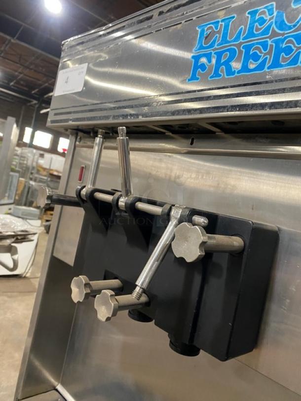 Electro Freeze twin/twist soft serve machine, stainless steel, 2 hoppers, 3 dispensers, on casters, commercial-grade.