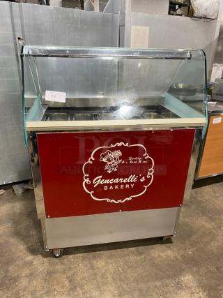 Commercial stainless steel 10-pan gelato case with rear sliding door access and casters, featuring Gencarelli's Bakery logo.