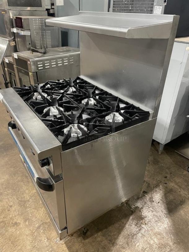 Radiance by Turbo Air commercial 6-burner stainless steel gas range/oven combo, with backsplash, overhead salamander shelf, and wired oven rack, on legs.