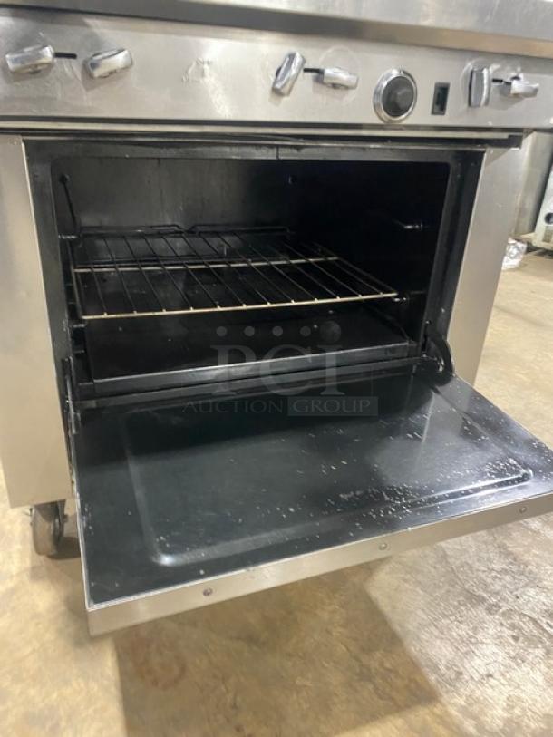Southbend S36D stainless steel 6-burner gas range/oven with wavy grates, backsplash, salamander shelf, and wired rack. On casters.