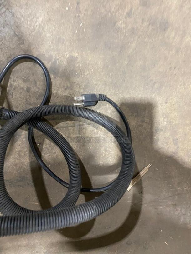 Black power cable with plug visible on concrete floor next to Coldline ICE180 ice maker.