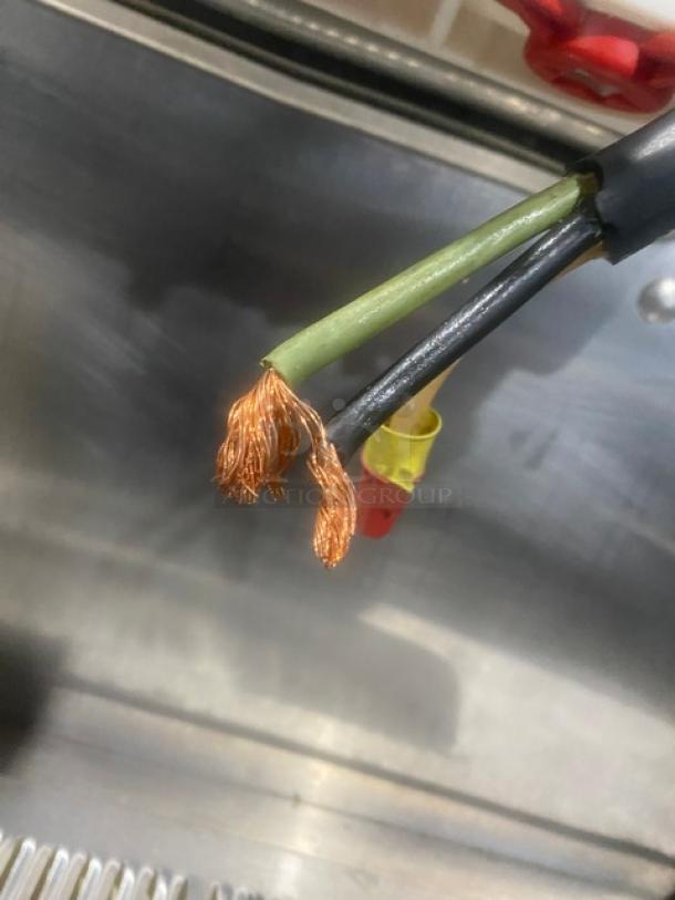 Close-up of a frayed electrical wire inside a Taylor soft serve machine model 8756P27.