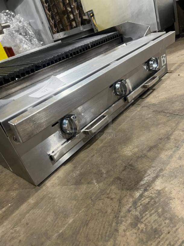 Commercial stainless steel gas-powered countertop char broiler, features multiple control knobs, sleek design, excellent condition.