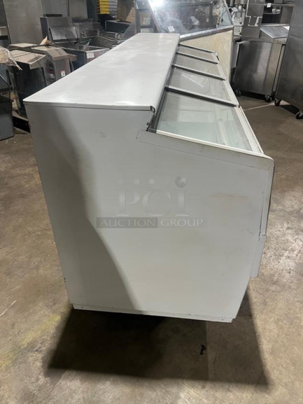 Hussmann LBN8 commercial freezer, white, 96" with 4 glass sliding doors, for ice cream/frozen food, in used condition.