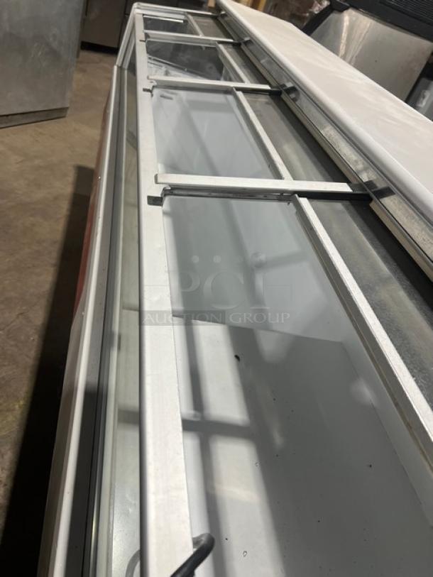 Hussmann LBN8 commercial ice cream merchandiser with 4 glass sliding doors, 96" width, white, in good condition. Model: LBN-8.