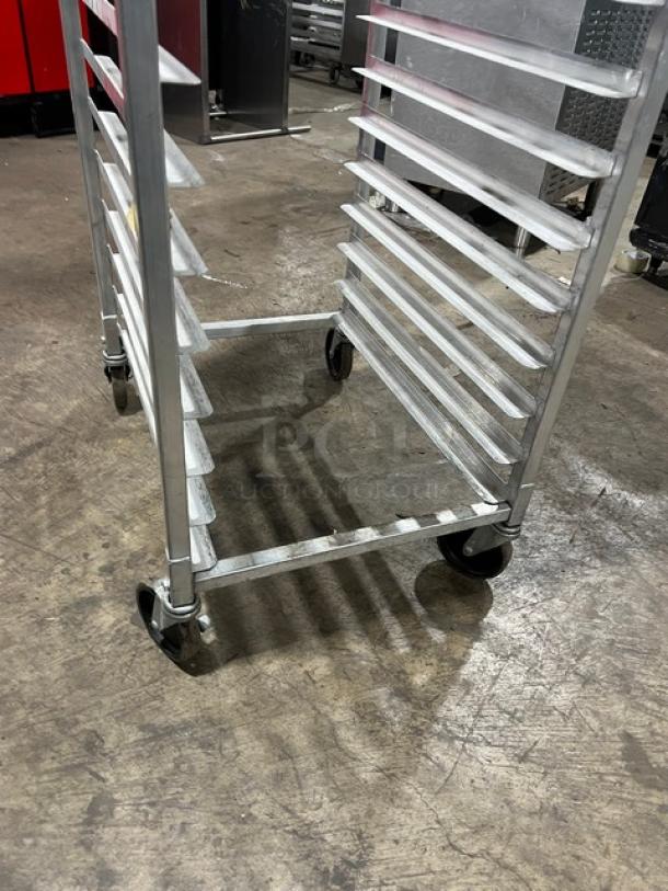 Commercial full-height aluminum bun/sheet pan rack, features multiple shelves, on casters for mobility, good condition.