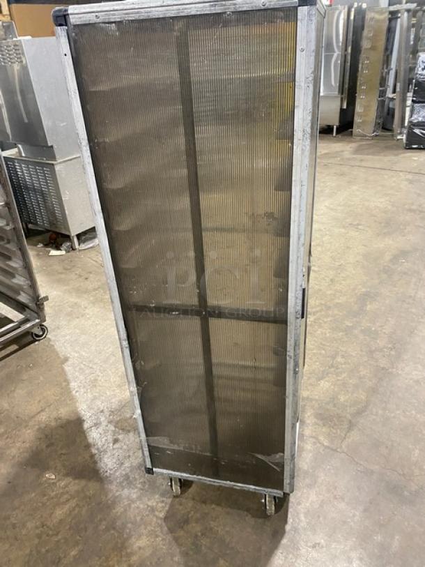 Commercial aluminum full-height bun/sheet pan rack with corrugated sidewalls and casters, industrial setting.
