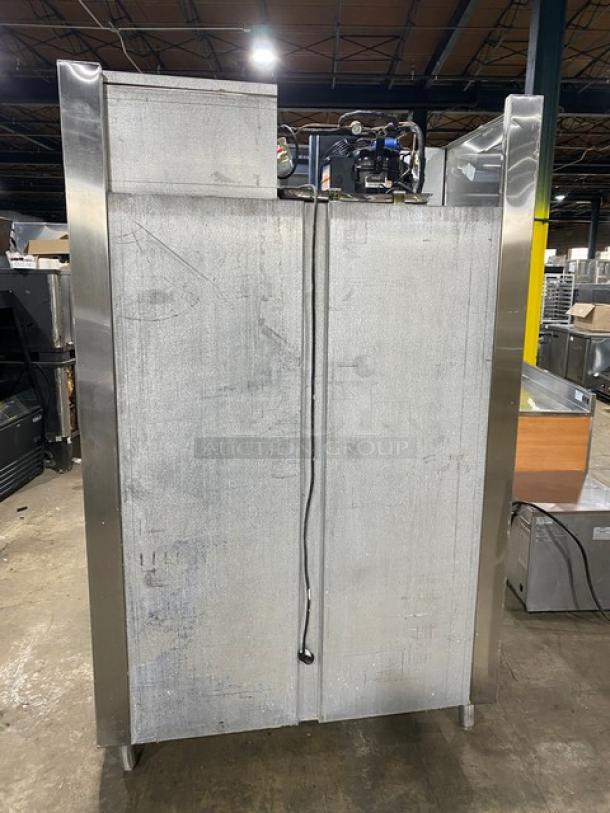 Traulsen commercial stainless steel 4-door refrigerator, Model AHT232NUT, with built-in pan slides, on legs, rear view.