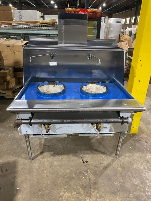 Commercial stainless steel gas-powered 2-burner Chinese wok range with backsplash, dual swivel spout faucet, and sturdy legs.