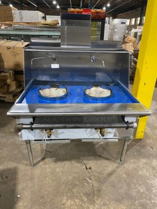 Commercial stainless steel gas-powered 2-burner Chinese wok range with backsplash, dual swivel spout faucet, and sturdy legs.