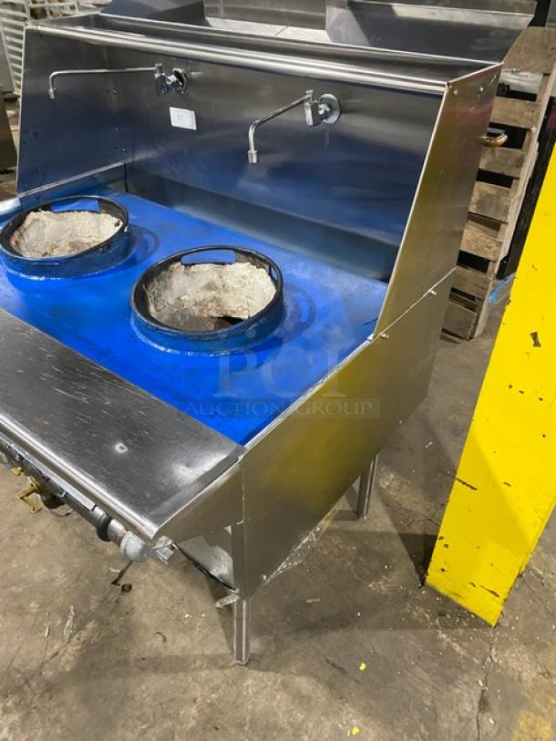 Commercial stainless steel 2-burner wok range with backsplash, dual swivel spout faucet, on legs. Gas powered, used condition.