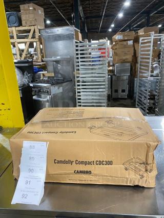 New Cambro Camdolly CDC300358 in box, on casters. Heavy-duty, red, compact design for commercial use.