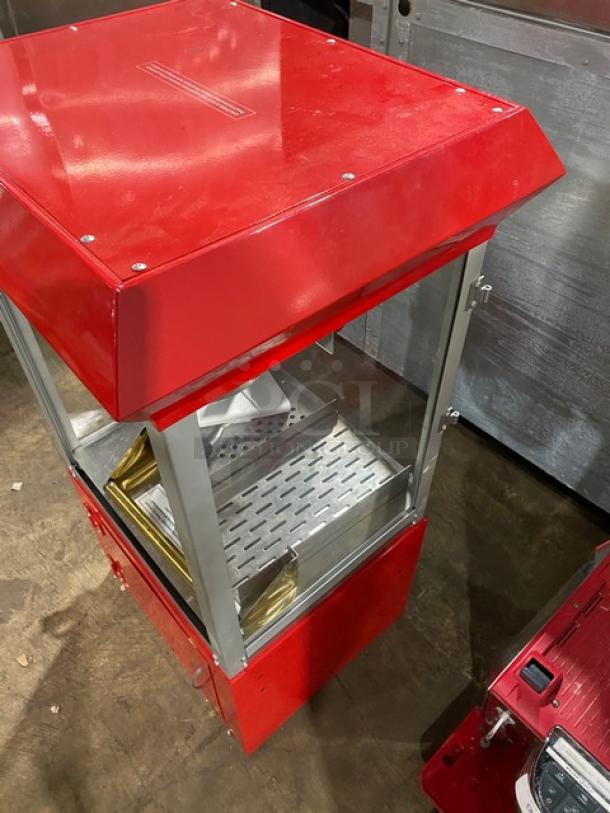 Carnival King red stainless steel popcorn machine with removable kettle, scoop, and cabinet storage. Features stand legs.