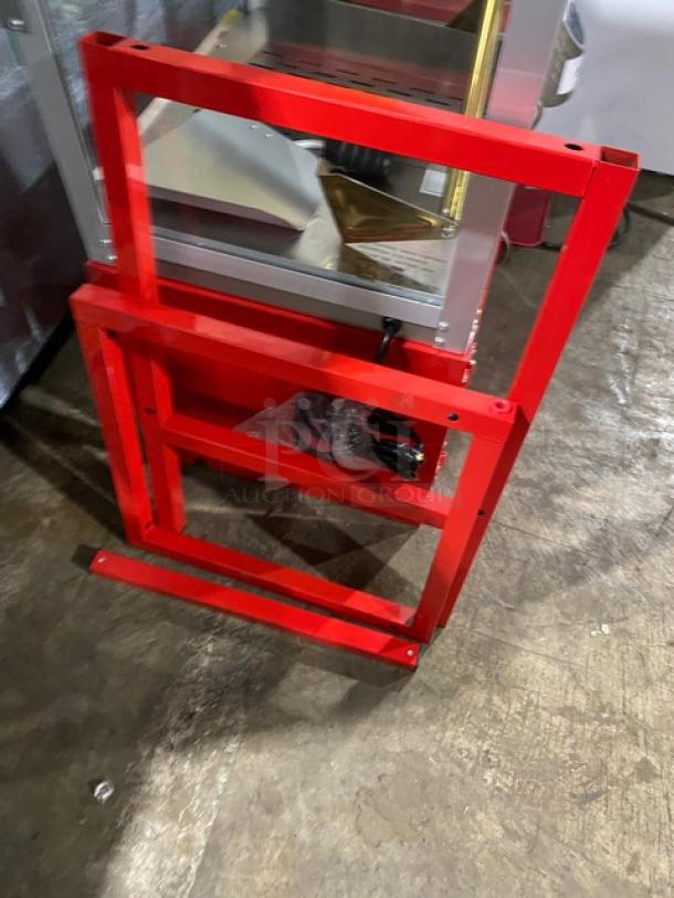 Carnival King red stainless steel electric popcorn machine with removable kettle, scoop, cabinet storage, and stand legs.