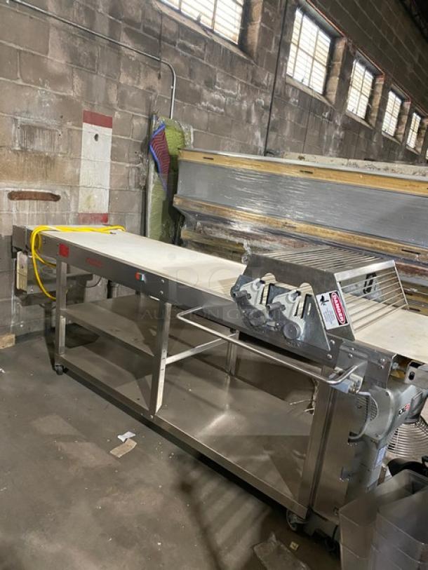 Rondo floor-style belt conveyor system, used, stainless steel, adjustable speed, safety labels visible, industrial setting.