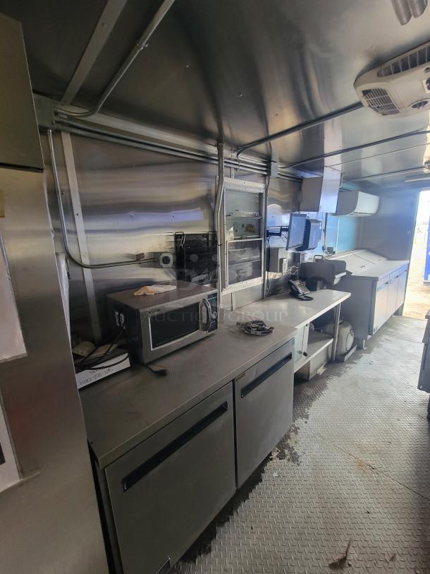 Fully equipped 24' Diamond Cargo mobile kitchen trailer interior with stainless steel appliances, microwave, and ample counter space.