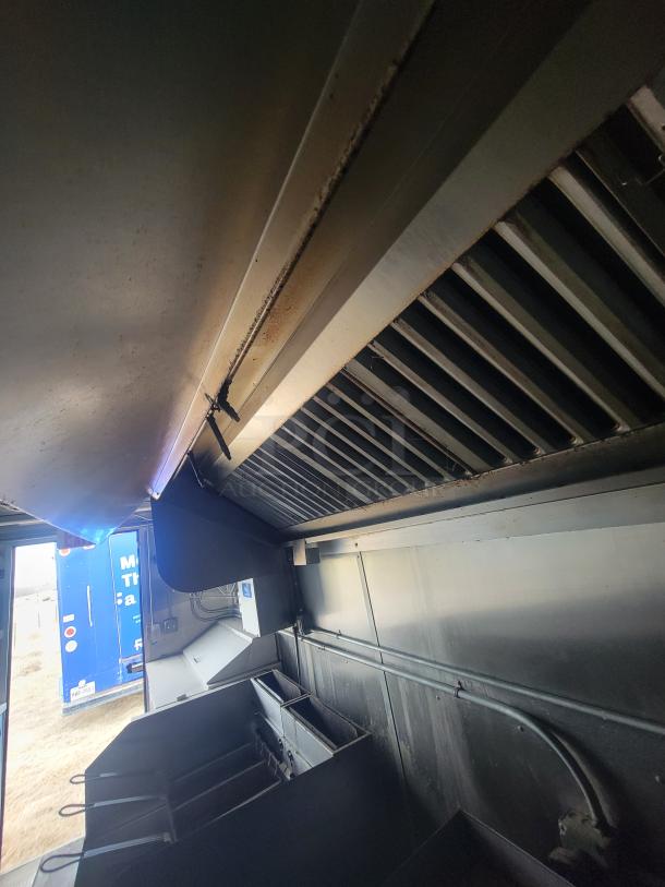 24' Diamond Cargo mobile kitchen trailer interior; features professional equipment setup. View of exhaust hood and fryers.