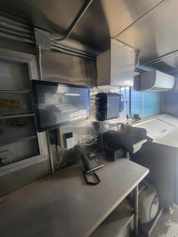 Interior of a 2021 Diamond Cargo 24' Mobile Kitchen Trailer, featuring stainless steel countertops, telephone, keypad, and equipment.