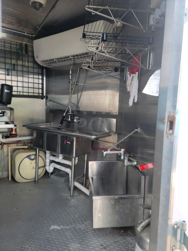 Haulmark 24' Mobile Kitchen interior, features stainless steel sinks, shelving, and climate control for high-volume food service.