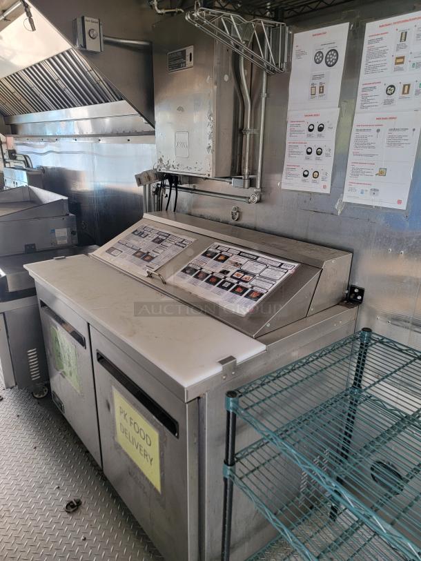 Haulmark 24' mobile kitchen interior with commercial refrigeration, fire suppression system, and control panels, suited for high-volume service.