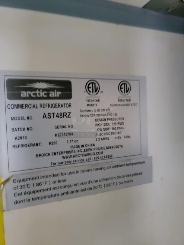 Arctic Air AST48RZ commercial refrigerator label with specs including model, serial number, refrigerant type, and usage guidelines.